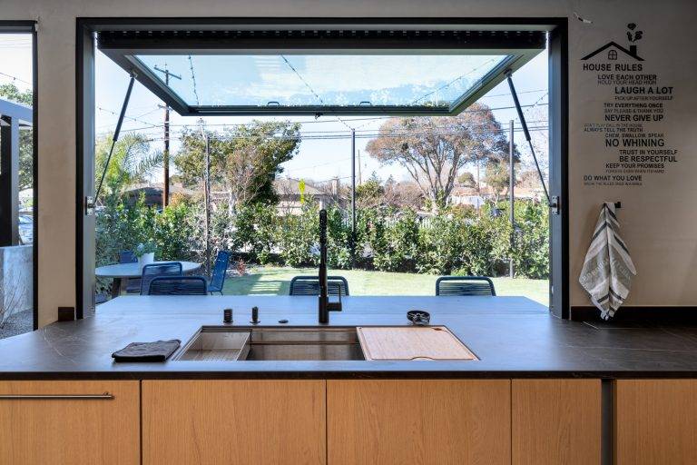 The kitchen includes a pass-through over the sink that opens to a dining area in the front yard. Photo by Boaz Meri courtesy VRchitects.