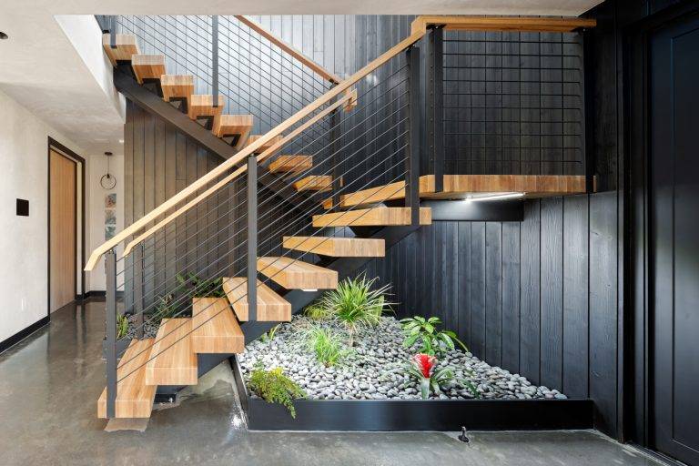 A steel string staircase leads to the second floor. Photo by Boaz Meri courtesy VRchitects.