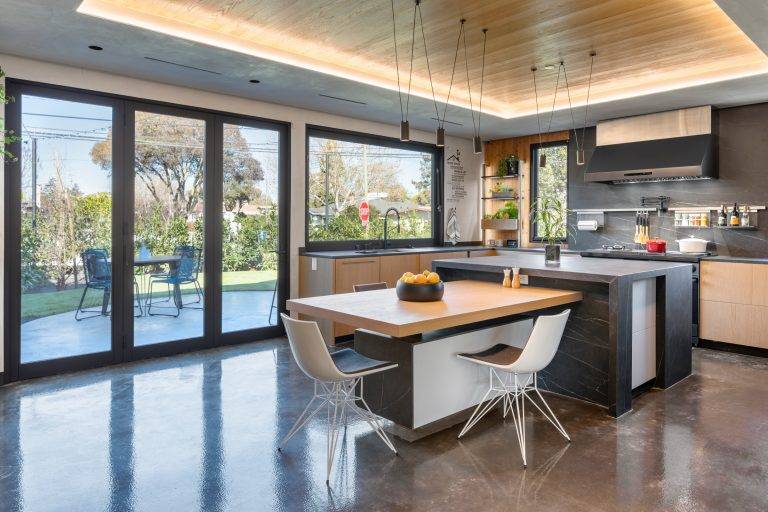 The kitchen was designed so more than one person could cook, and everyone could eat comfortably at the island, which steps down to table height. Photo by Boaz Meri courtesy VRchitects.