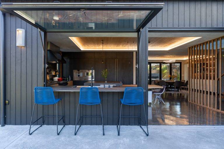 A pass-through window and bifold door open up the kitchen to the outdoors. Photo by Boaz Meri courtesy VRchitects.