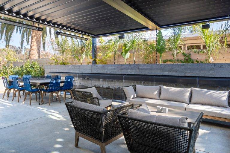 A view of the backyard shows the waterfall wall and the louvered pergola. Photo by Boaz Meri courtesy VRchitects.