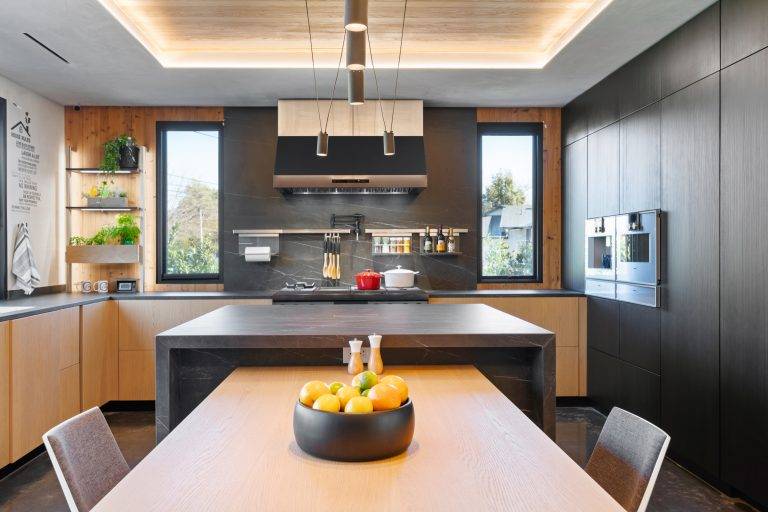 The kitchen features Sapien Stone porcelain countertops, a six-burner Dacor range and a built-in appliance cabinet. Photo by Boaz Meri courtesy VRchitects.